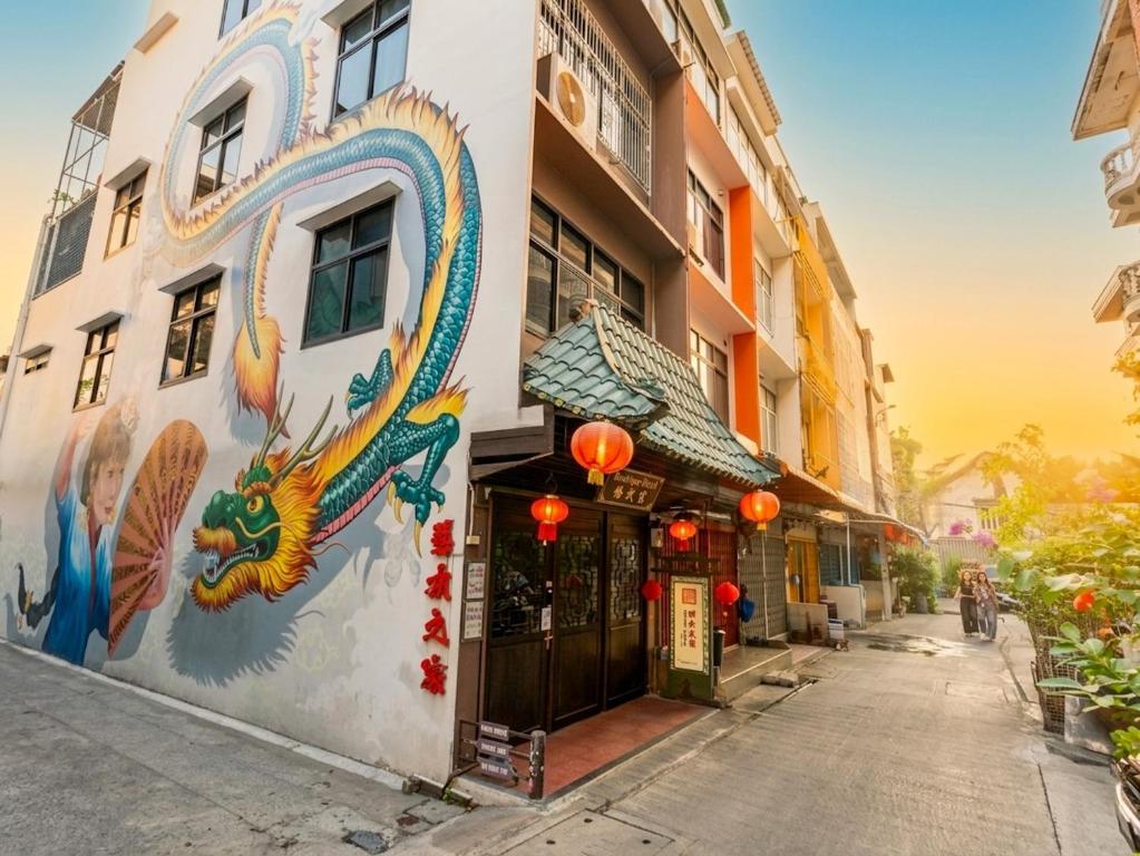 a building with a painting of a dragon on it at Taladnoi Paint House in Bangkok