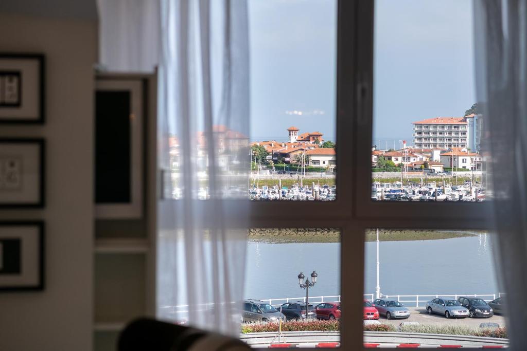 a window with a view of a parking lot at Apartamento Platas Centro in Ribadesella