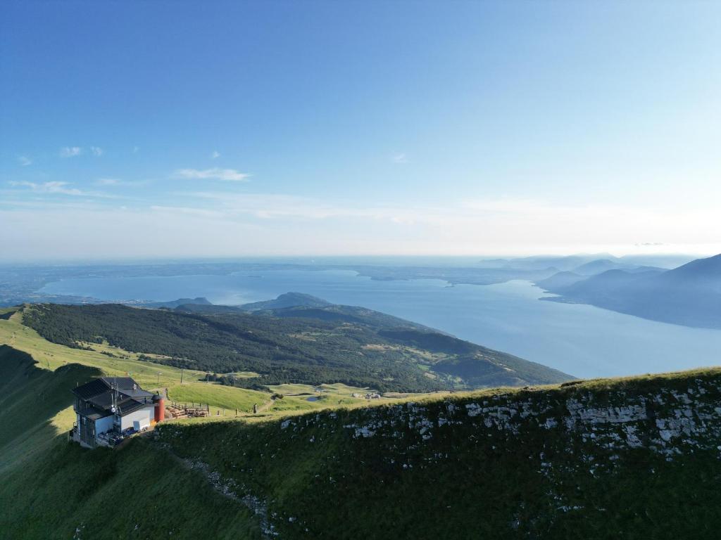a house on top of a hill with a body of water at Rifugio Chierego - 1911m in Brenzone sul Garda