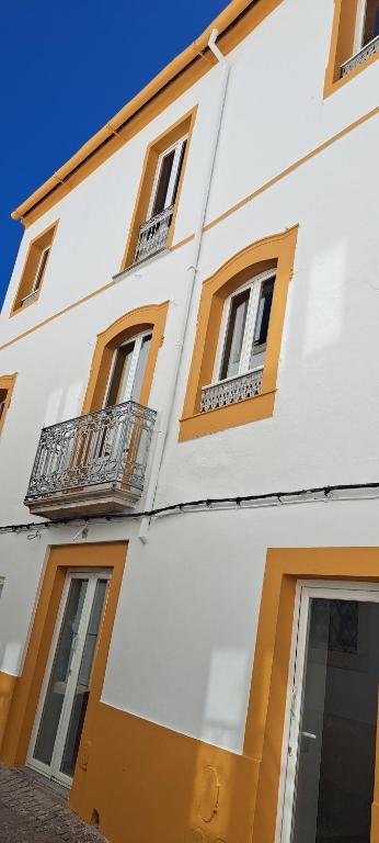 a white building with windows and a balcony at Elvasguesthouse in Elvas