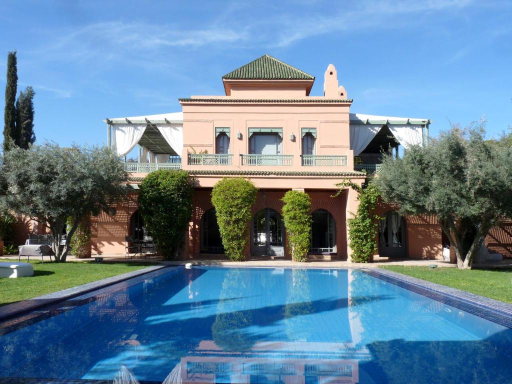 une maison avec une piscine en face d'un bâtiment dans l'établissement Villa Palmeraie, à Marrakech