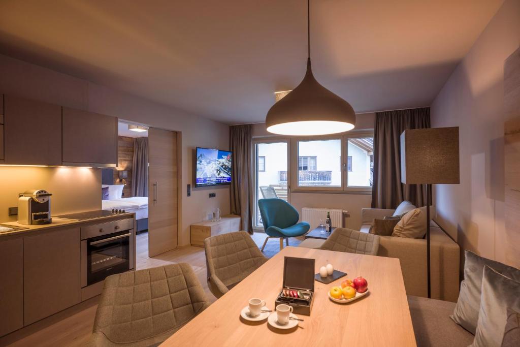 a kitchen and a living room with a table in a room at Postresidenz in Mayrhofen