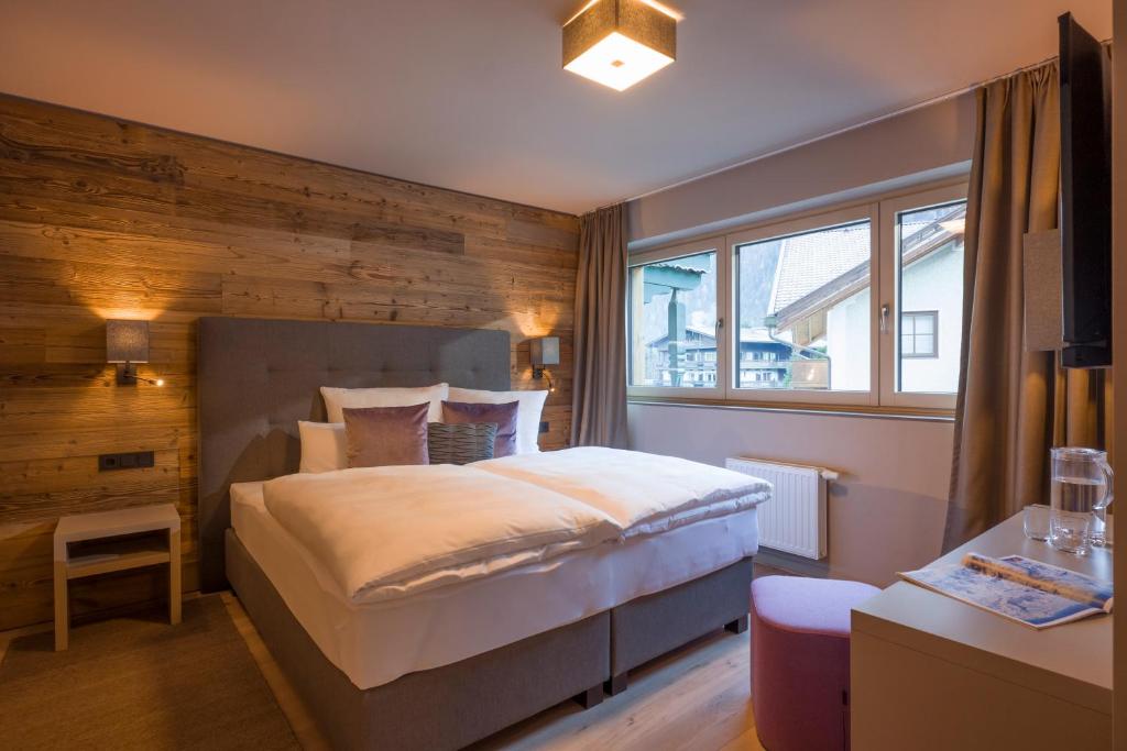 a bedroom with a bed with a wooden wall at Postresidenz in Mayrhofen