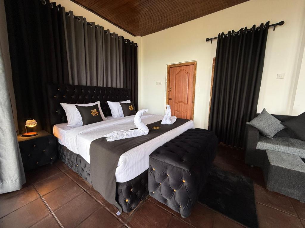 a bedroom with a large bed with black curtains at Eden Heaven Villa in Nuwara Eliya
