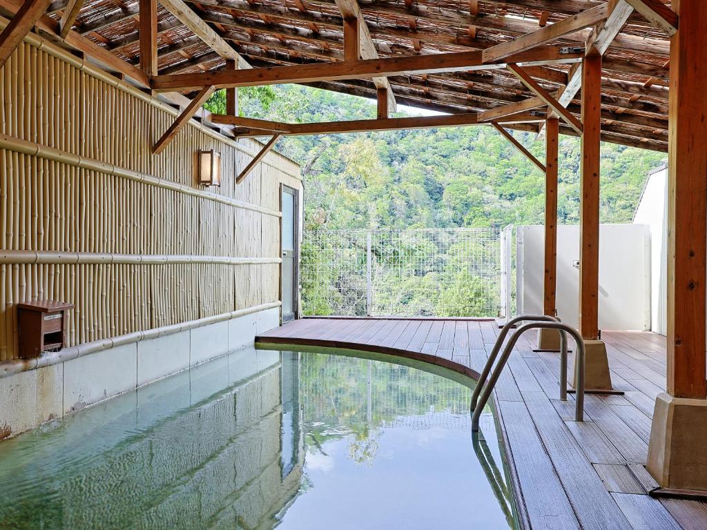 a swimming pool in a house with a wooden ceiling at Itoen Hotel Hakone Yumoto in Hakone