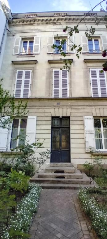 a white house with a blue door and windows at Studio hyper centre Angers in Angers