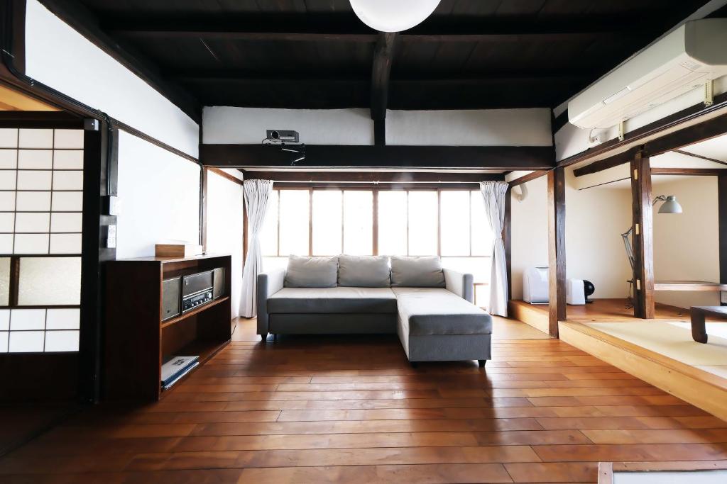a living room with a couch and a large window at Entire Traditional House, Pet Friendly,貸切古民家,最大9名,ペット可, 長野岡谷IC5分,ファミリー歓迎 in Okaya