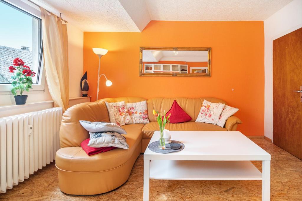 an orange living room with a couch and a table at Über den Dächern in Cochem Altstadt in Cochem
