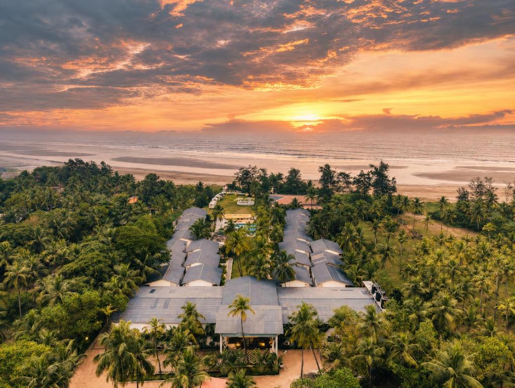 an aerial view of a resort on the beach at sunset at Foxoso La Beach Resort & Spa in Old Goa