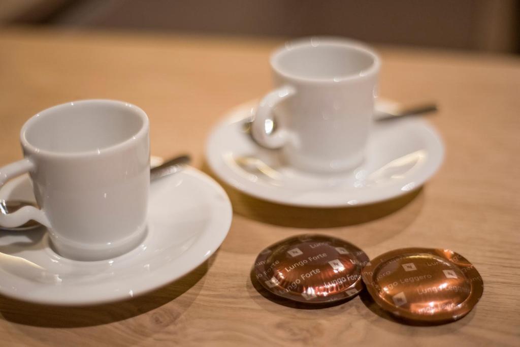 two white cups and saucers on a wooden table at Postresidenz in Mayrhofen