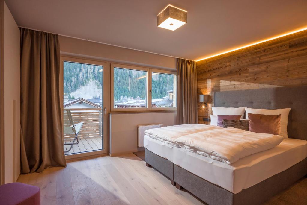 a bedroom with a large bed and a large window at Postresidenz in Mayrhofen