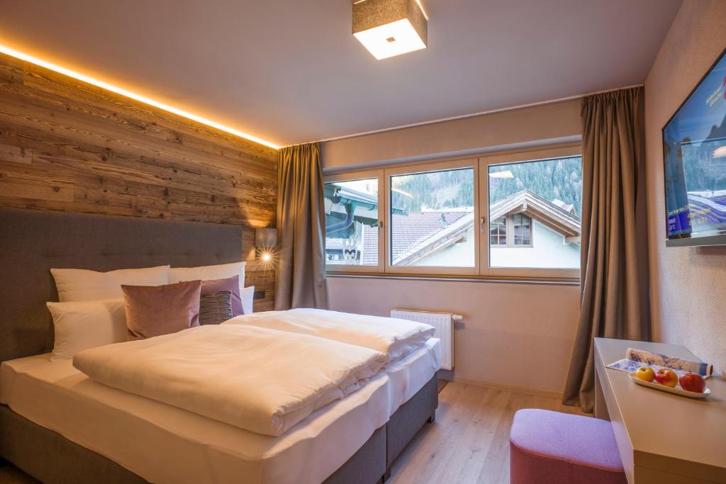 a bedroom with a large bed and a window at Postresidenz in Mayrhofen