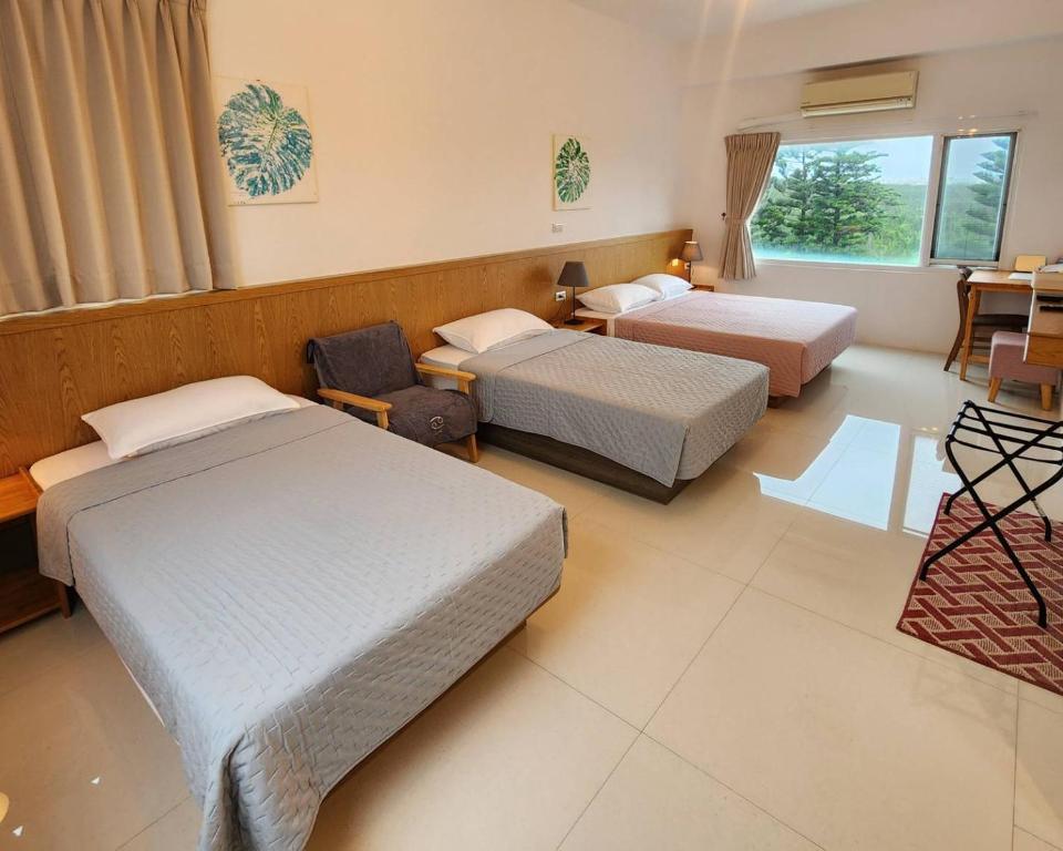 a hotel room with two beds and a chair at Little Molly B&B in Magong