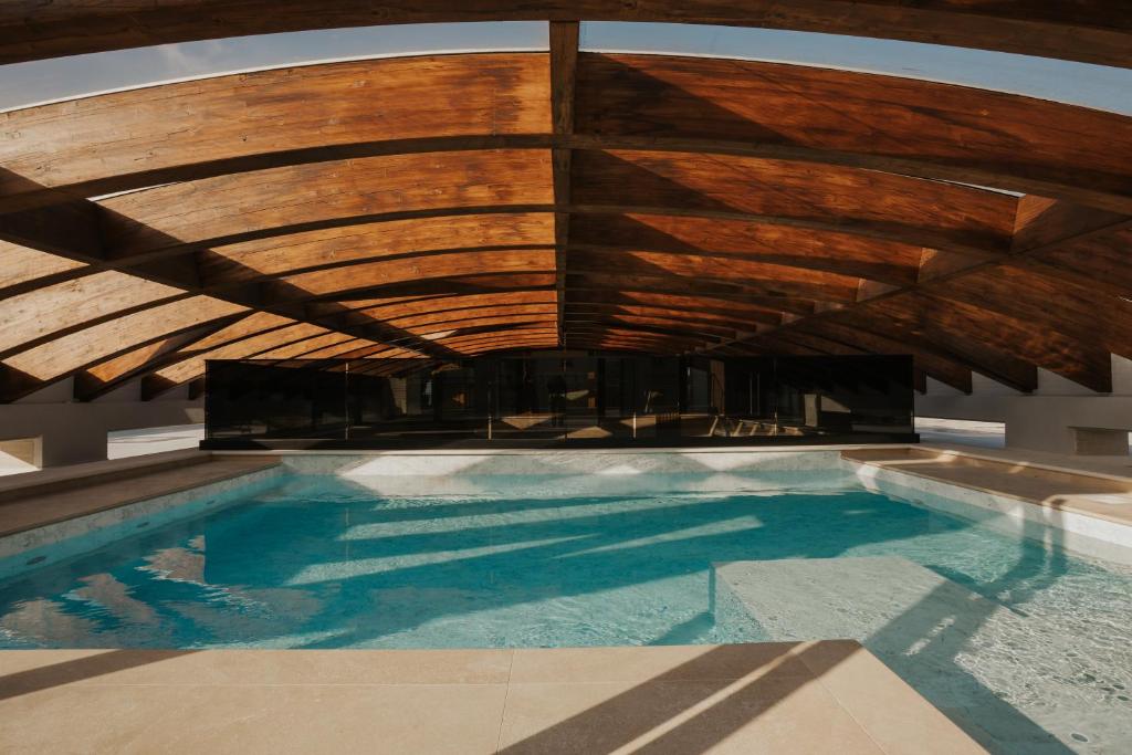 a swimming pool with a wooden ceiling and a boat at Afrodite Luxury Residence & Spa in Pescara
