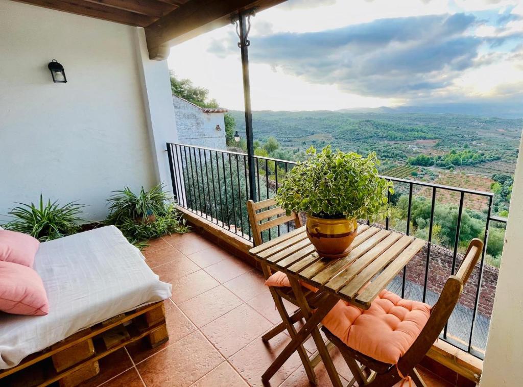 a table with a potted plant on a balcony at El Portal de Vilafamés in Vilafamés