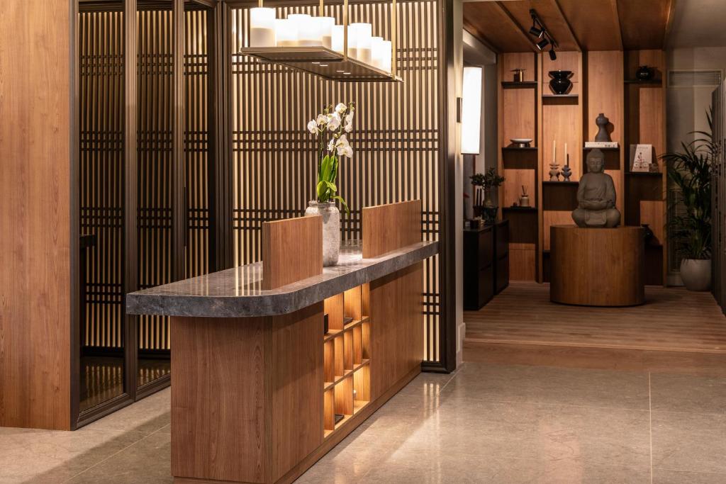 eine Lobby mit einem Tresen, auf dem eine Vase mit Blumen steht in der Unterkunft Darya-J in Athen
