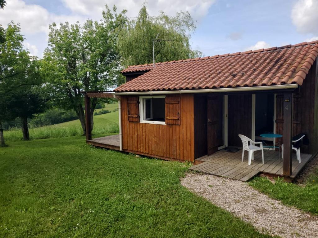 a wooden cabin with a deck and a table at Chalets du Causse 4 in Gelle
