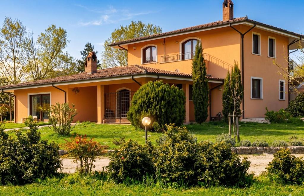 an orange house with a green yard at Bed & Breakfast Le Piagge in Scurcola Marsicana