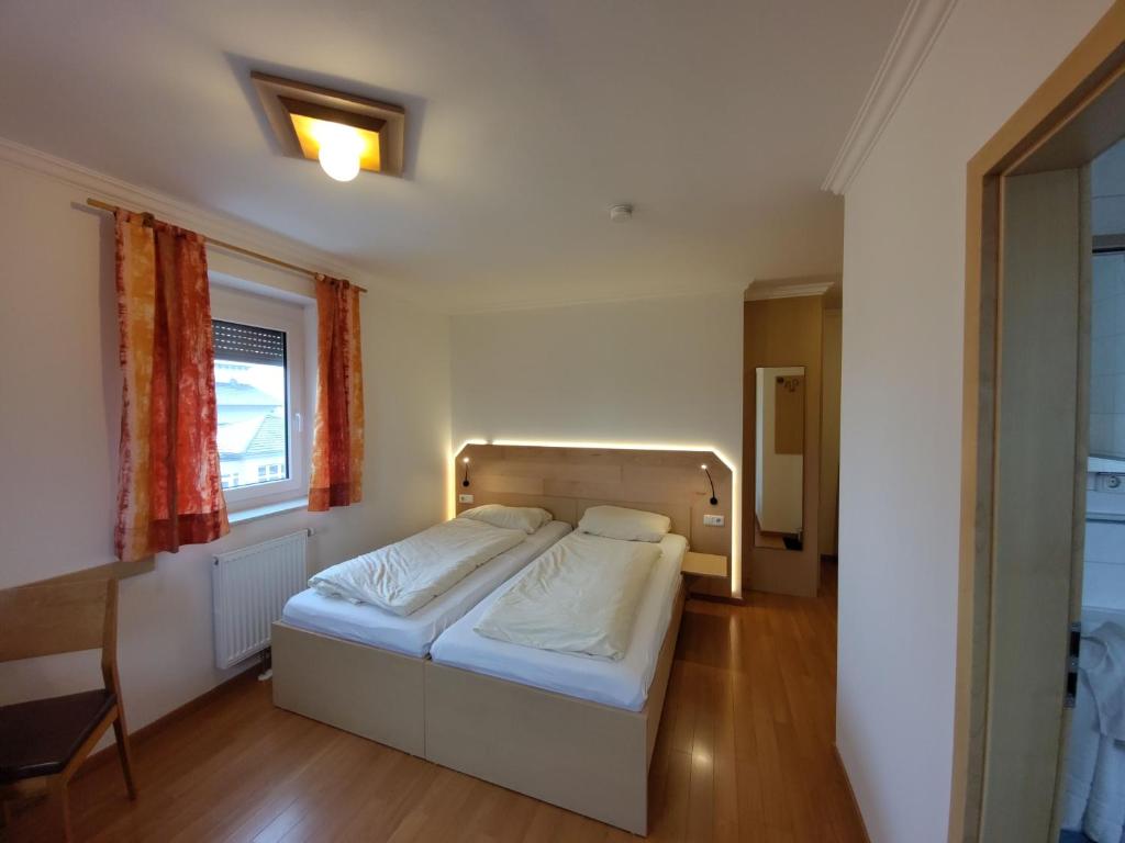 a bedroom with a bed and a window at Schirmer`s Hotelino in Röhrmoos