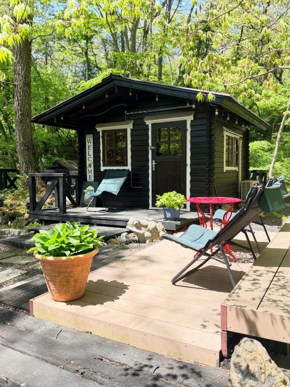 a small black cabin with a deck and a patio at Foresta Karuizawa 6 "Glamping & Tent" for 8 people in Karuizawa