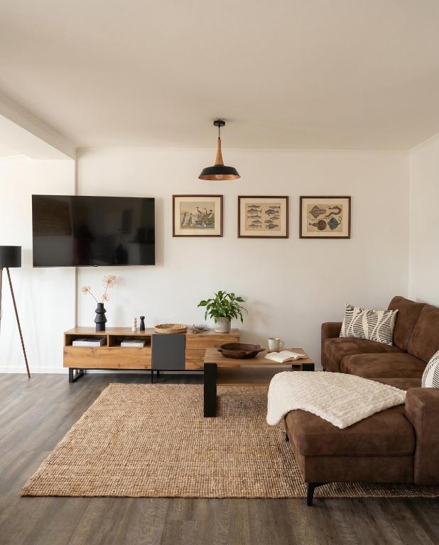 a living room with a couch and a table at Stilvolles Apartment mit Wintergarten, Balkon & Parkblick - VILLA KAETHE am Kurpark in Warnemünde