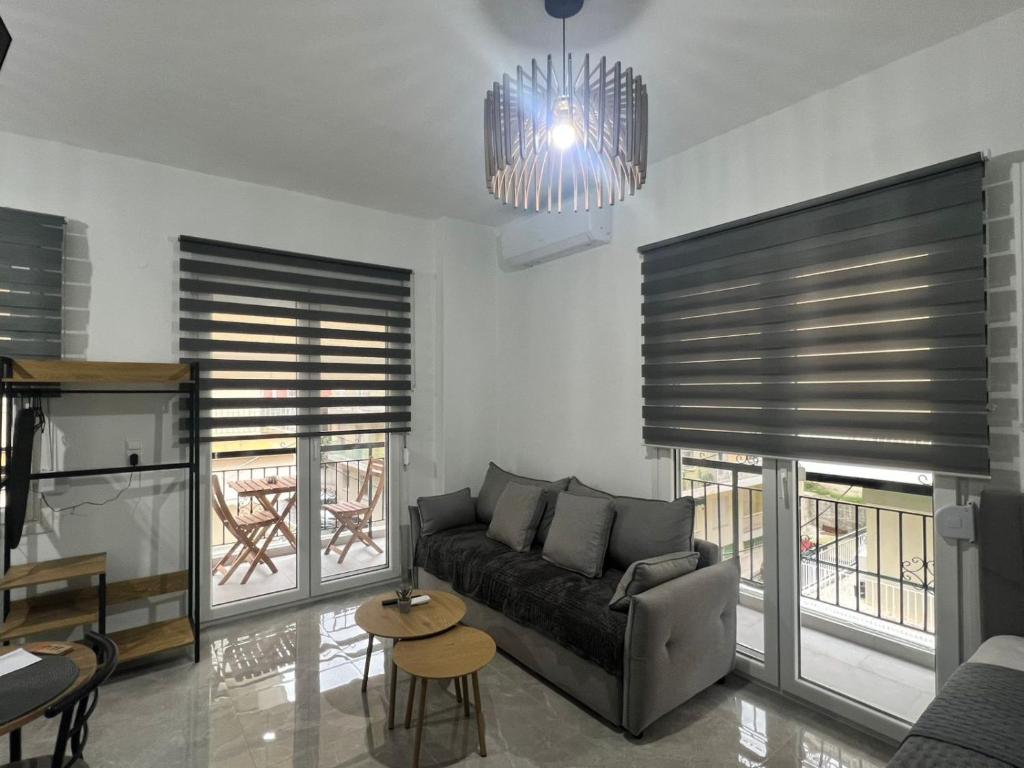 a living room with a couch and some windows at Drama Homes Argiroudi in Drama
