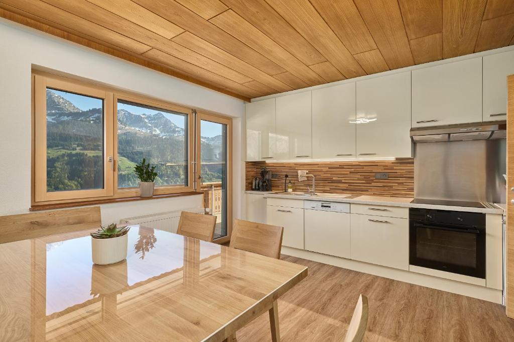 a kitchen with a table and chairs and mountains at Grundwert Apartment in Sonntag