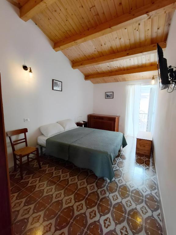 a bedroom with a bed and a chair in a room at Santanna106 in Santa Domenica