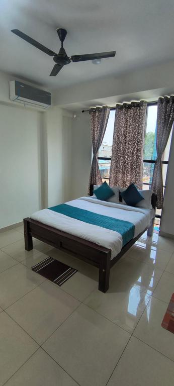 a bedroom with a large bed with a ceiling fan at Sky Light Mysore in Mysore South