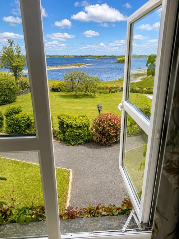 an open window with a view of the water at Corrib View Country House in Killarone