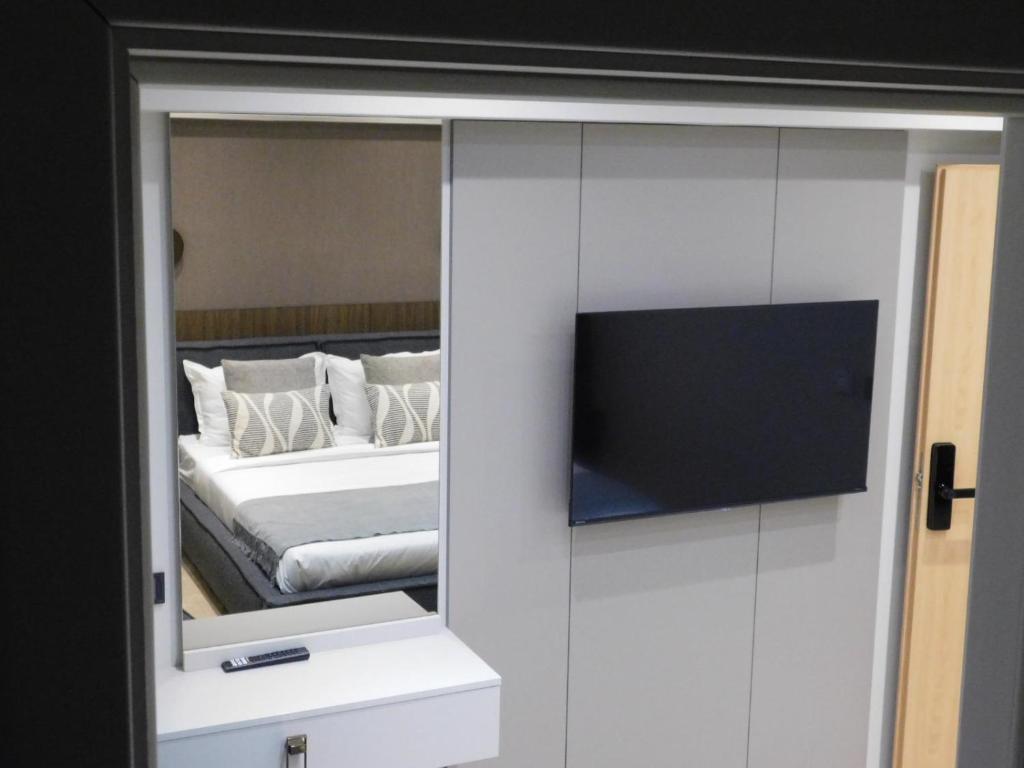 a bedroom with a mirror and a bed with a tv at SFERA Boutique Rooms in Iaşi