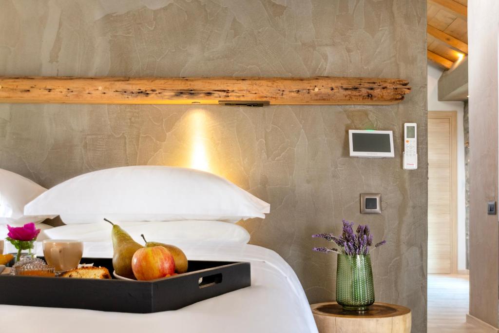a bedroom with a bed with a tray of fruit on it at Evoras Boutique Hotel in Xirokámbion