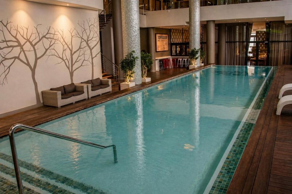 a large swimming pool in a hotel lobby at Beach, Restaurants, Shopping, Park, Pier - nearby in Durban