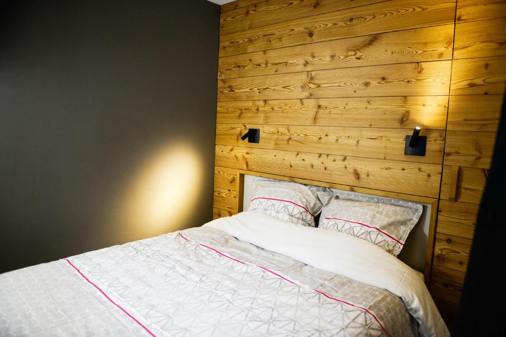 - une chambre avec un lit et une tête de lit en bois dans l'établissement La Chabane, à Chamonix-Mont-Blanc
