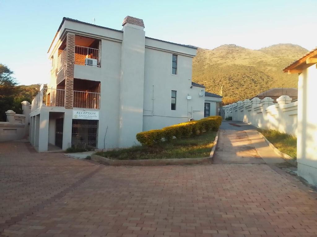 a white building with a brick driveway at The Social in Burgersfort