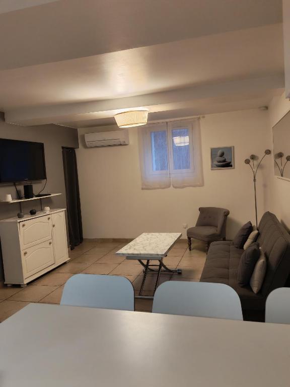 a living room with a couch and a table and chairs at Maison de campagne in Aubagne
