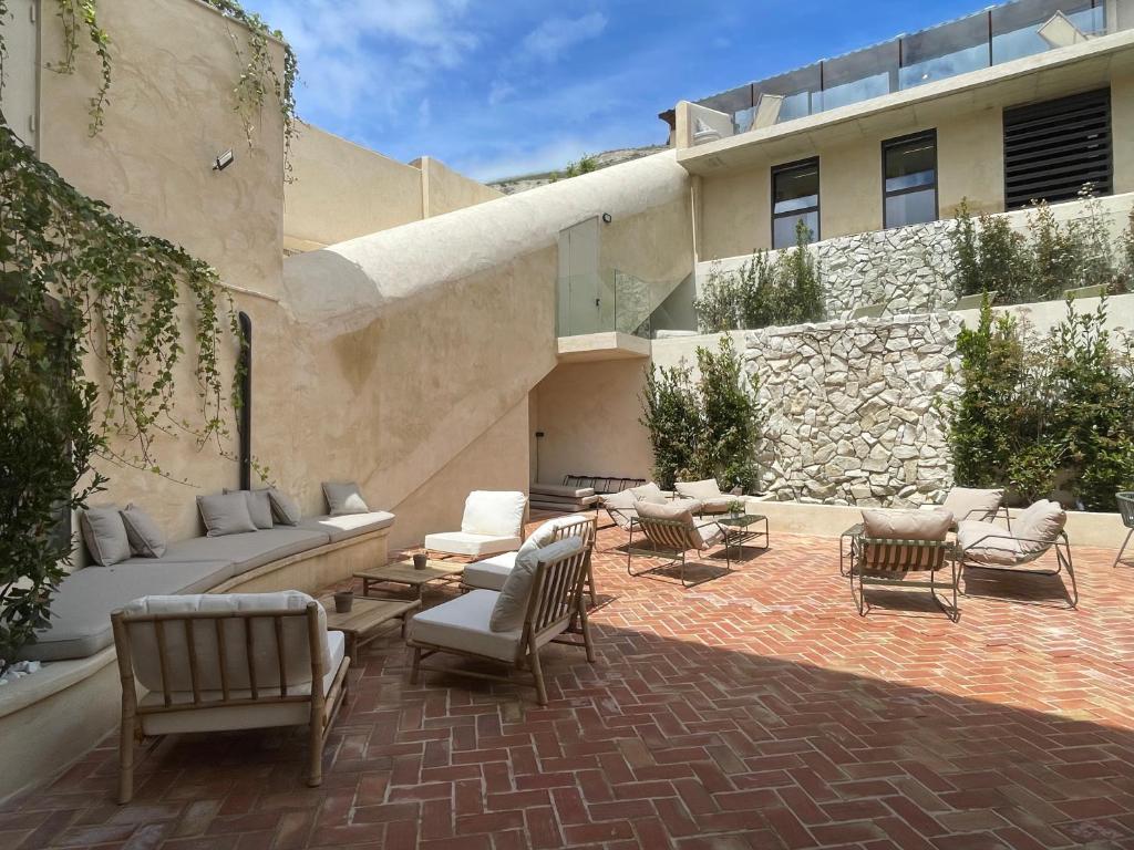 a patio with chairs and couches in front of a building at Hotel SPA John Te Lo Busca in Castrojeriz