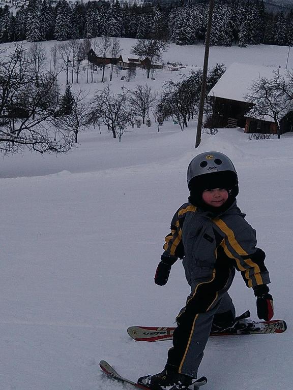 a young child is on skis in the snow at Apartmány Kuřátko in Benecko