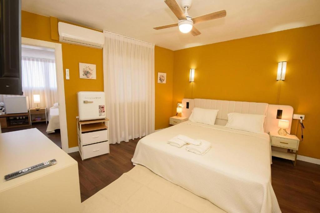 a bedroom with a white bed and a yellow wall at Casa Boutique Con Terraza Ideal in Dos Hermanas
