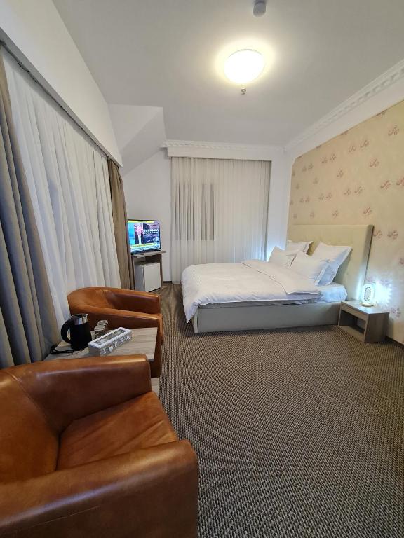 a hotel room with a bed and a couch at Casa cu pastravi in Sinaia