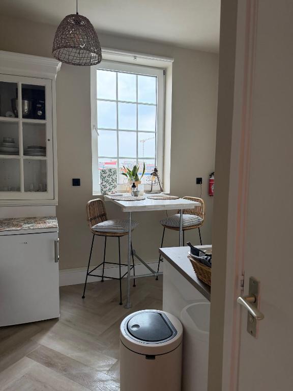 a kitchen with a table and chairs and a window at Mel's Pintxos winebar & Aparthotel in Zandvoort