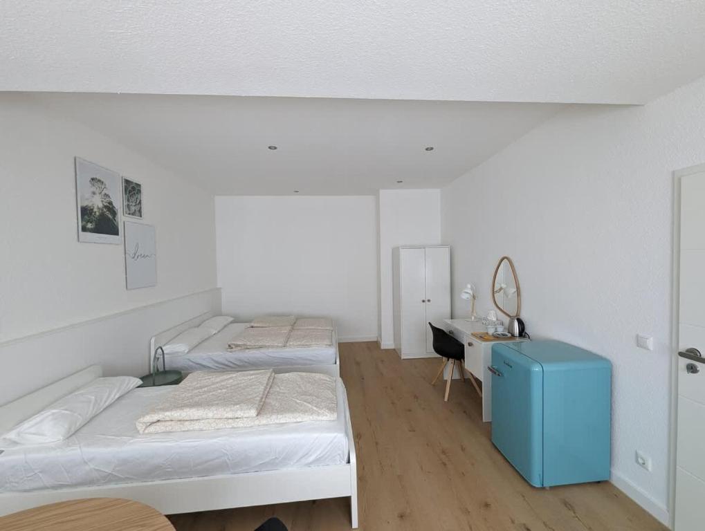 a white room with two beds and a desk at HarmoNest 1 Mgladbach South in Mönchengladbach