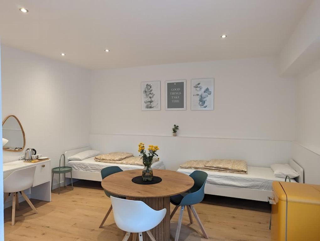a room with two beds and a table and chairs at HarmoNest 2 Mgladbach south in Mönchengladbach