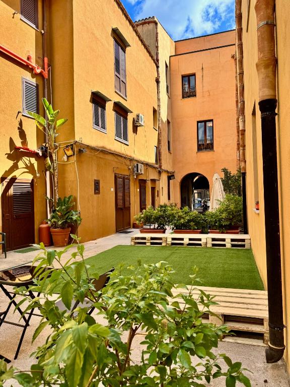 a courtyard with a green lawn in a building at La Magione in Palermo