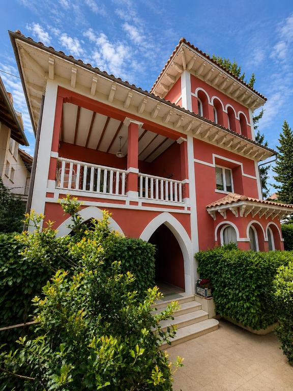 a red house with a balcony and bushes at Apartamento del Conde in Jaca