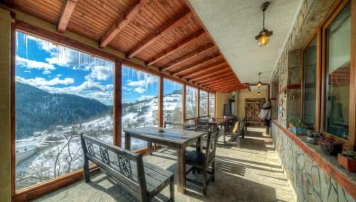 a dining room with a table and a view of a mountain at Rhodope House Momchil Yunak in Momchilovtsi