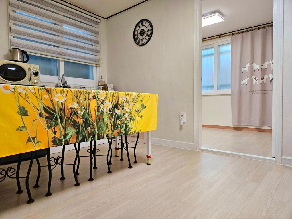 a kitchen with a yellow table with flowers on it at 행궁동-House2 in Suwon