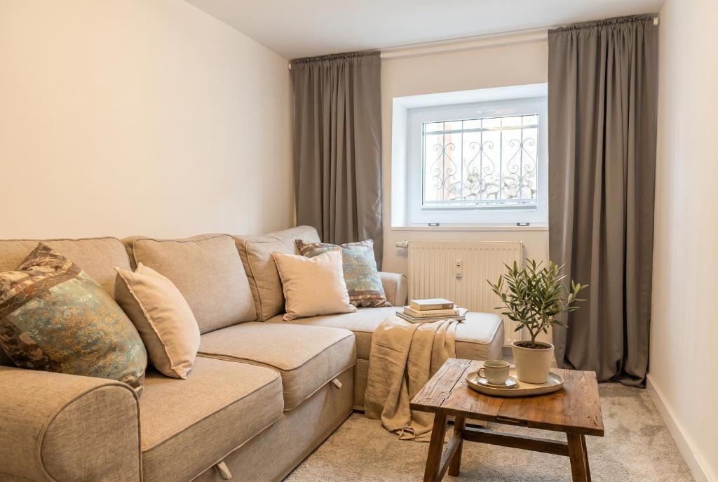 a living room with a couch and a table at Strandnest VILLA KAETHE am Kurpark - gemütliche 60qm Ferienwohnung für Zwei in Warnemünde