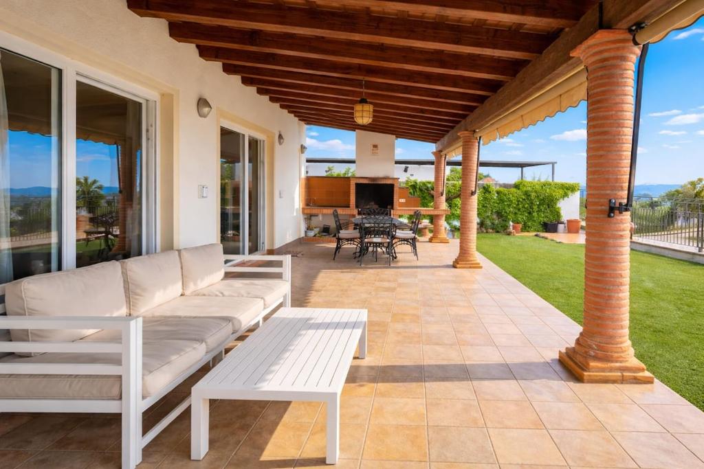 a porch with a couch and a table on a patio at Winahost Casa Nívar in Nívar