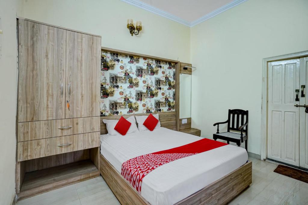 a bedroom with a bed with red pillows at Hotel O Dayal Heritage in Hazārībāg